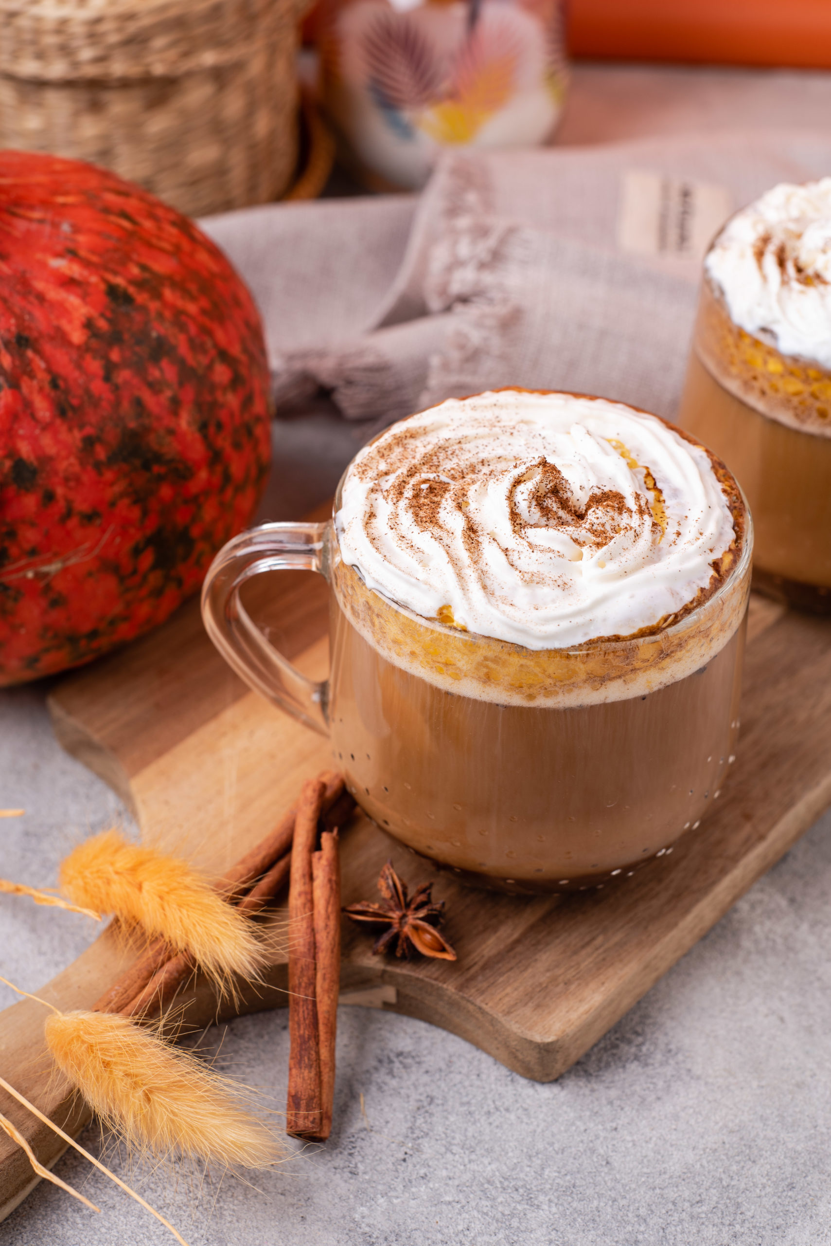 blogilates healthy pumpkin spice latte in clear mug topped with coconut whipped cream side view