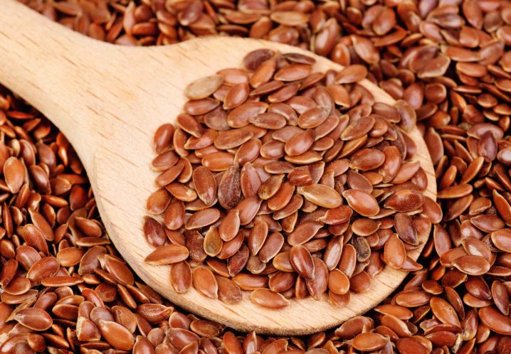 close up of flax seeds and wooden spoon food background
