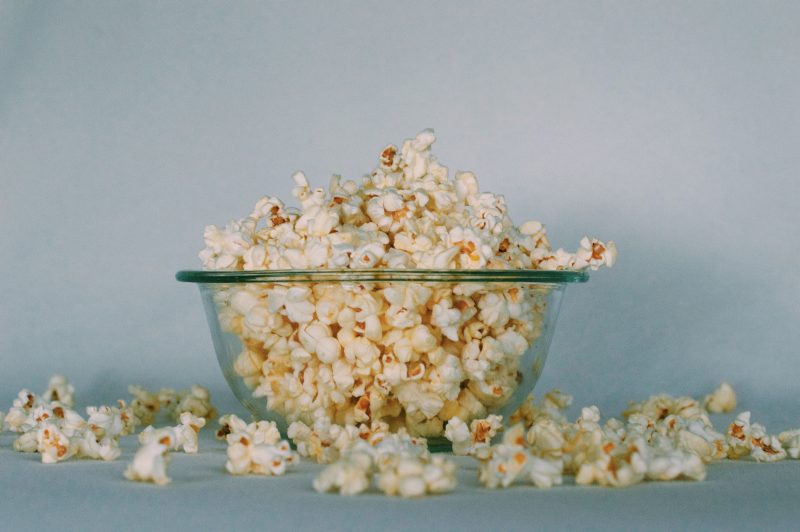 glass bowl of popcorn grey background