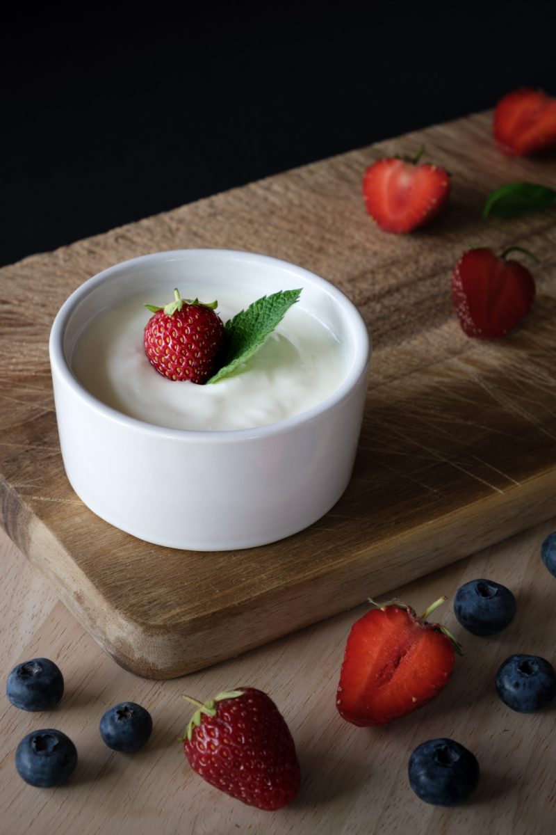 blogilates yogurt with berries in white bowl on cutting board boost immunity