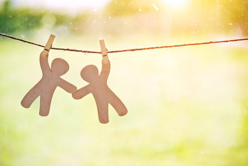 paper dolls holding hands on clothesline support