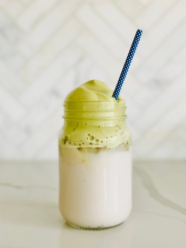 blogilates whipped matcha recipe in glass jar on counter with blue straw