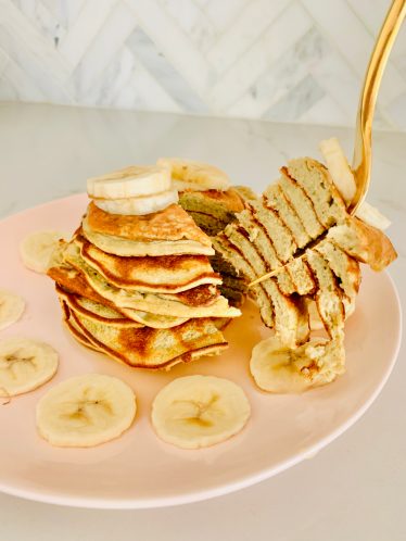 blogilates protein pancakes with sliced banana on pink plate