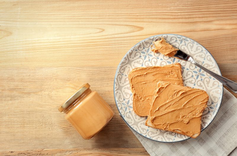 peanut butter on toast on patterned plate on wood table