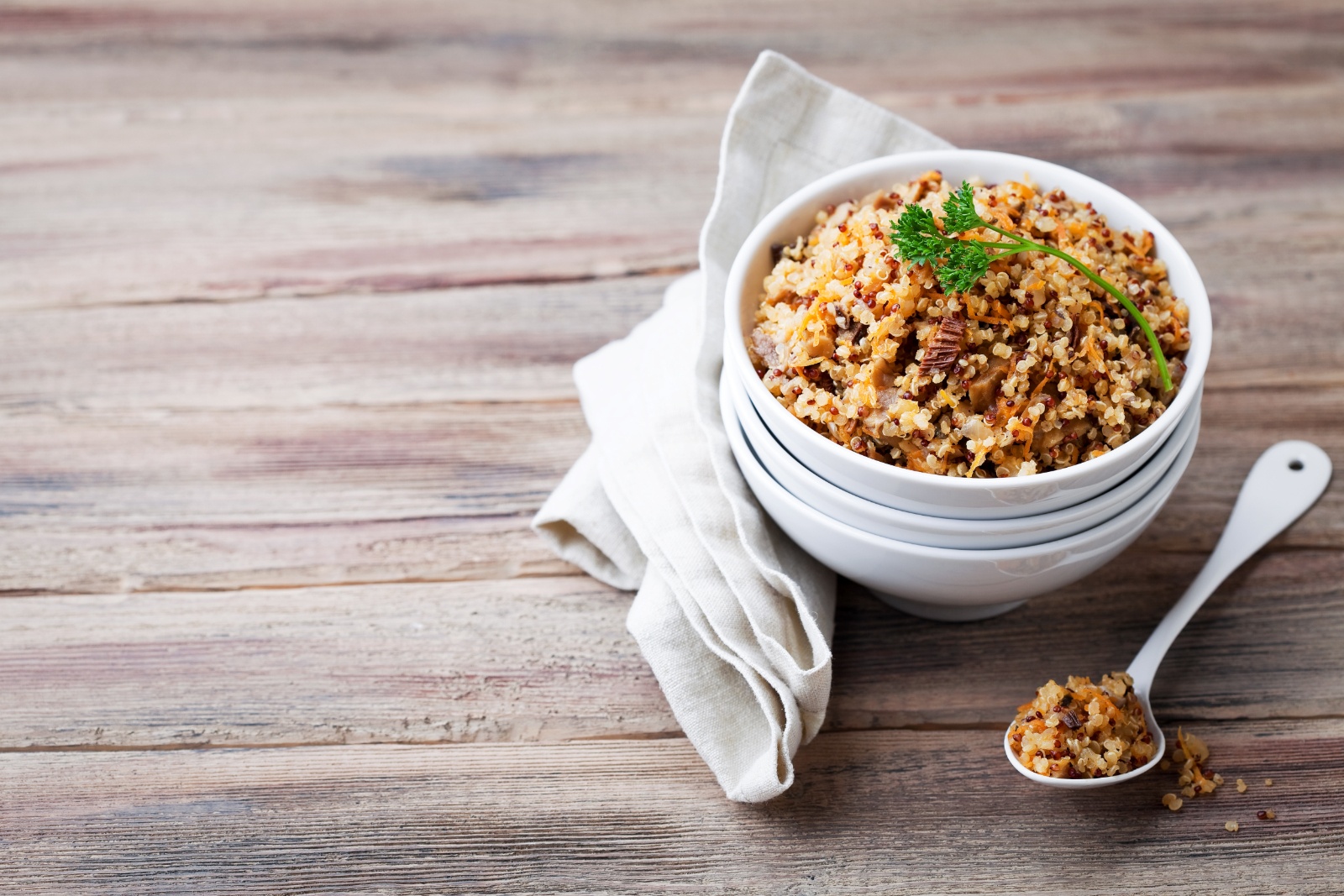 quinoa in a white bowl on a wood table