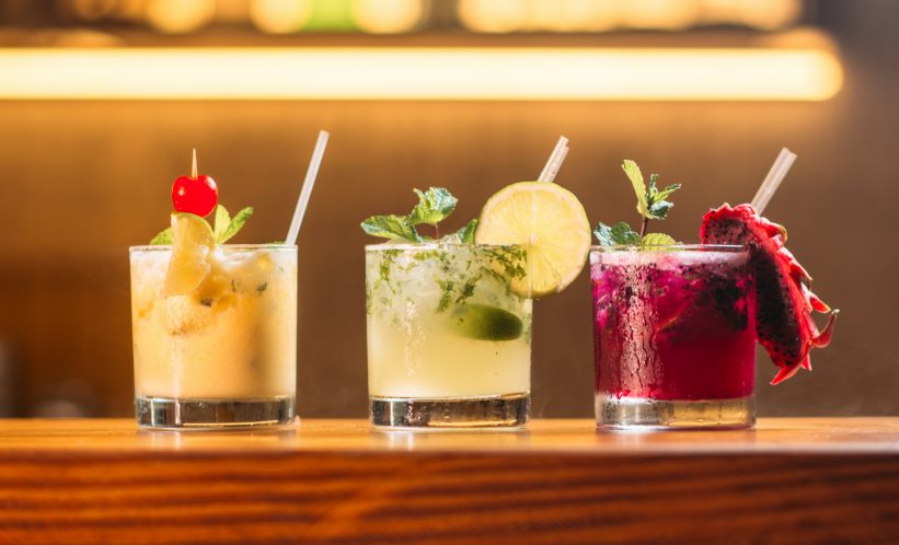 colorful cocktails with straws on bar