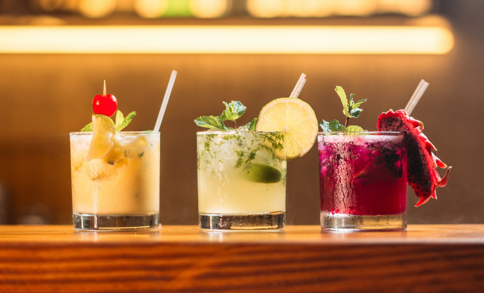 colorful cocktails with straws on bar