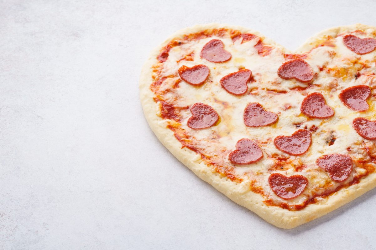 heart shaped pepperoni pizza on white background