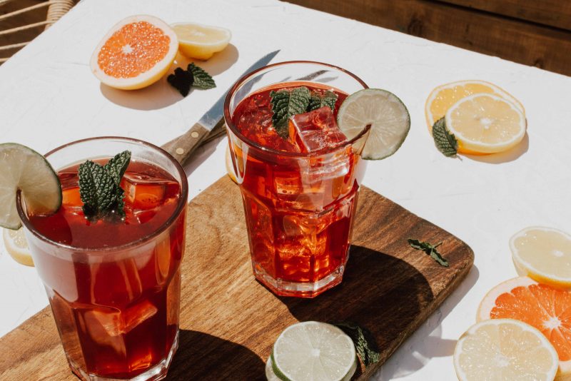 glasses of tea on a cutting board with sliced citrus fruits