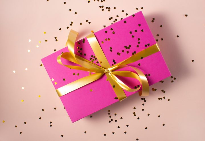 gift wrapped in pink paper with gold ribbon and glitter
