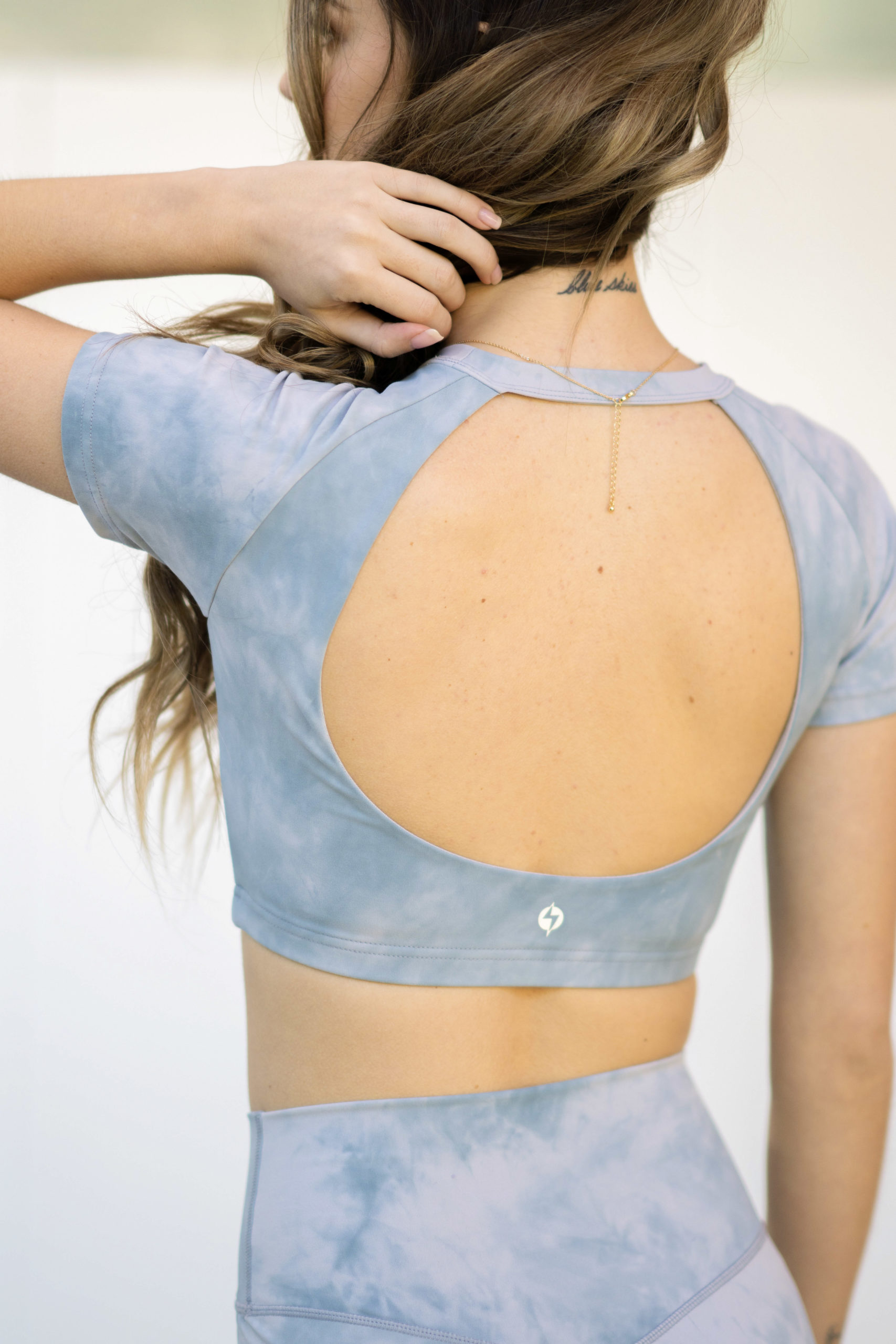 model wearing popflex marble collection baby bliss tee open back sky marble