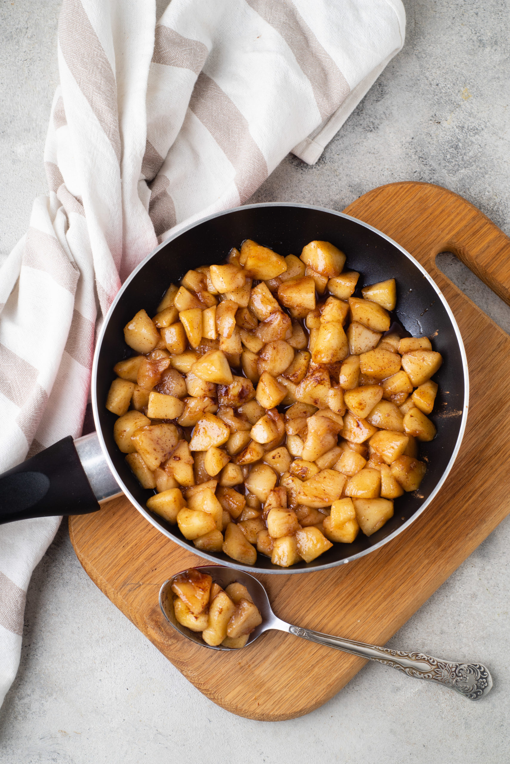 sauteed cinnamon apples healthy dessert recipe in a pan with spoon