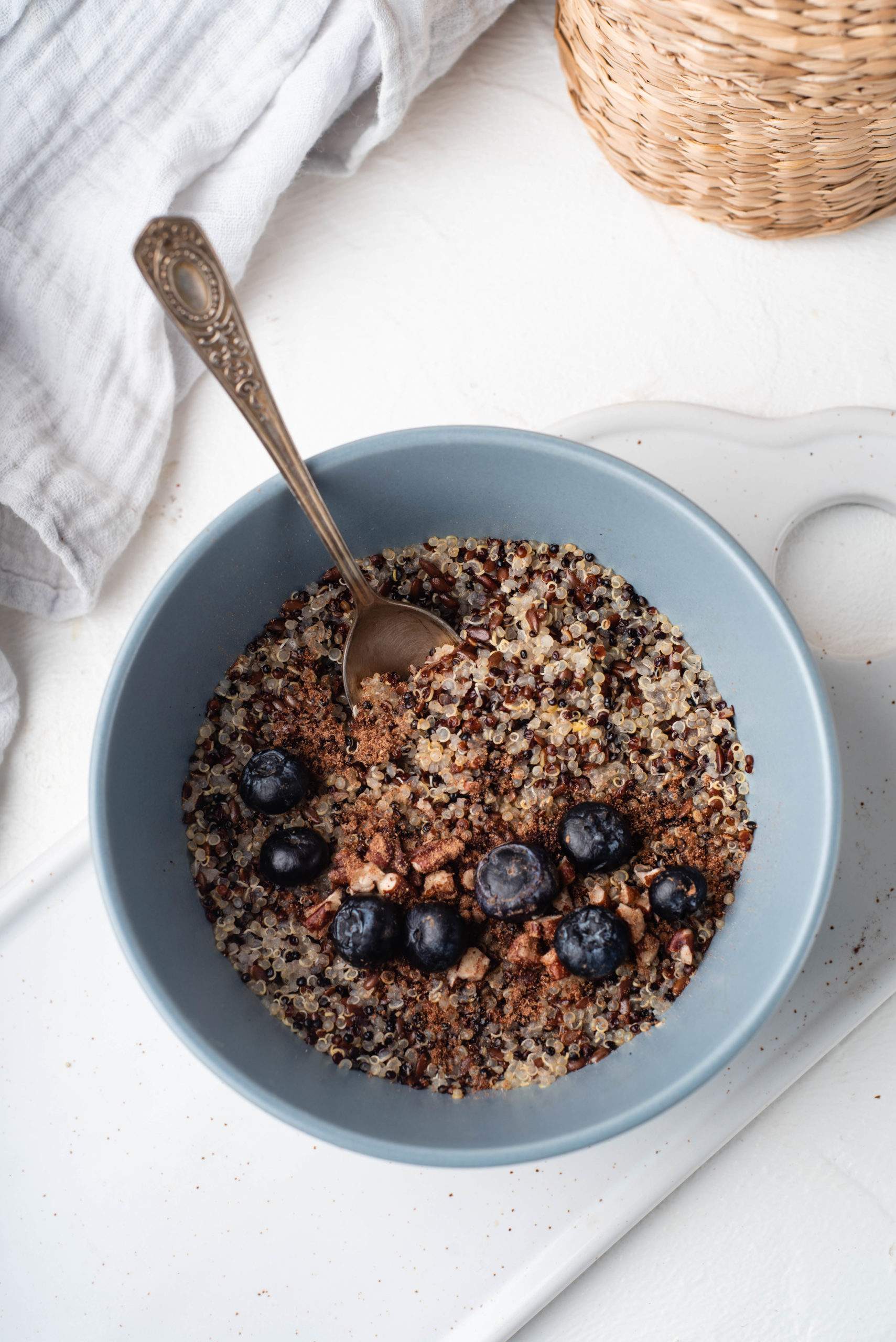 bowl of breakfast quinoa topped with cinnamon and blueberries