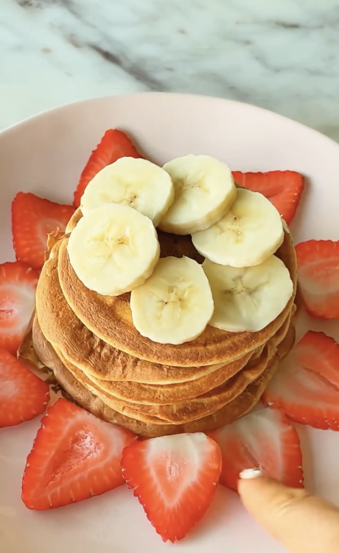 stack of high protein pancakes with bananas and strawberries