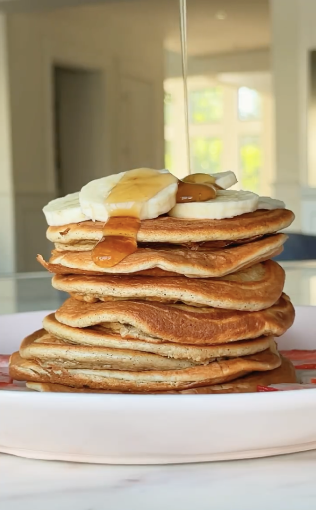 stack of protein pancakes with banana slices and syrup drizzle blogilates top 10 breakfast recipes