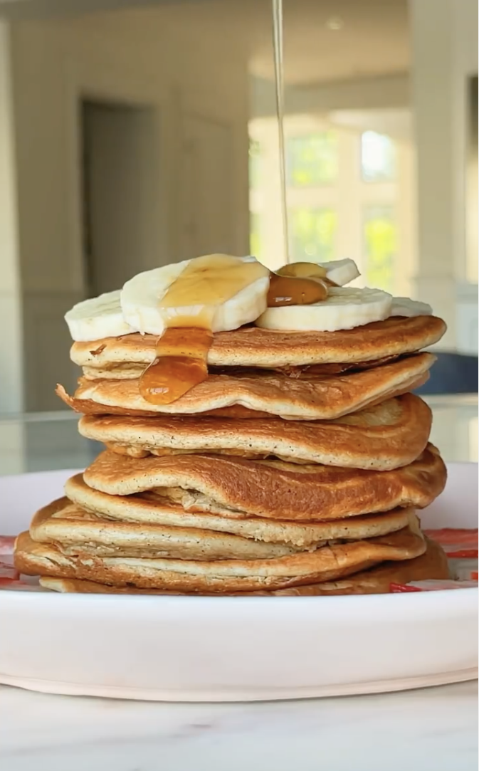 stack of protein pancakes with banana slices and syrup drizzle blogilates top 10 breakfast recipes