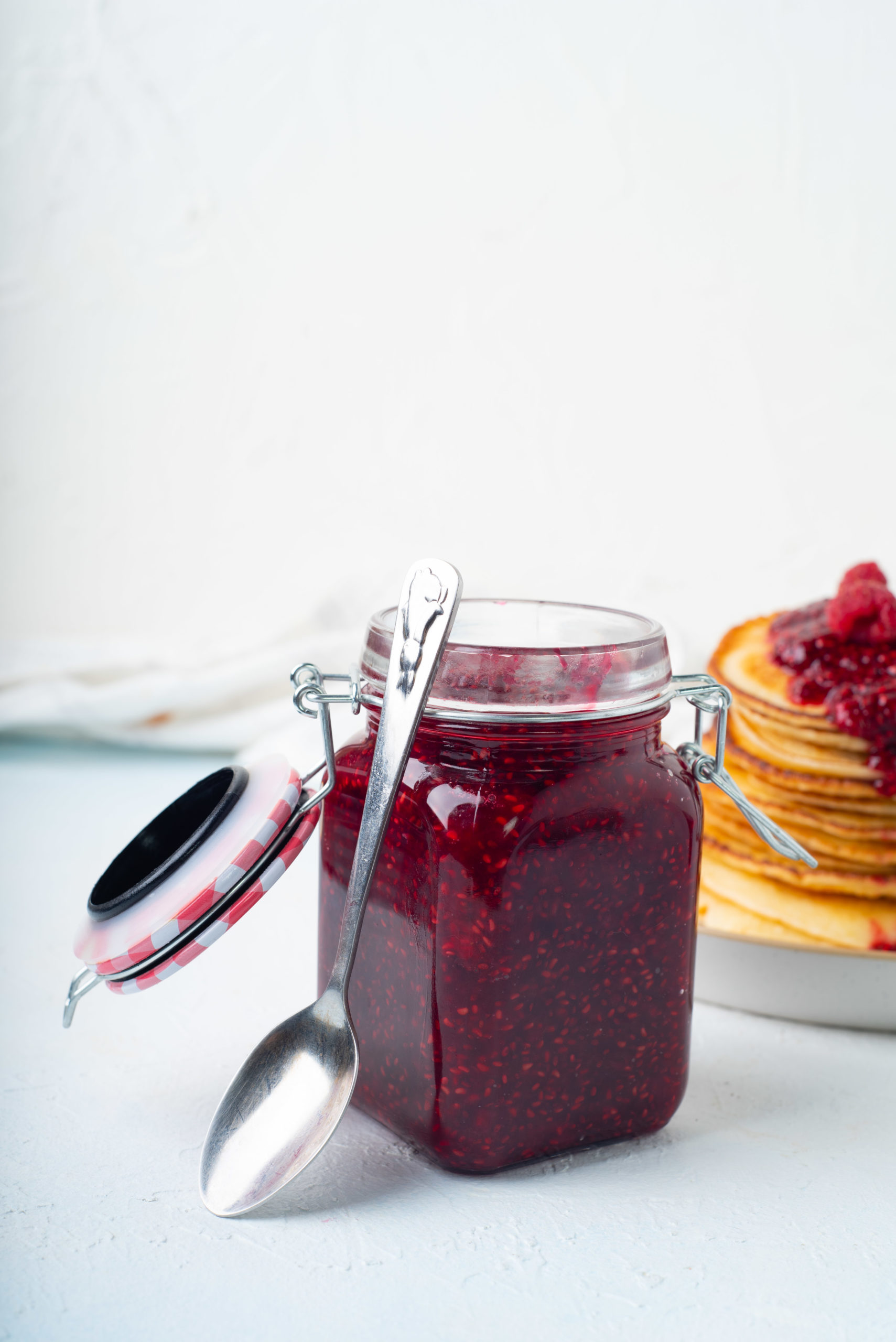 jar filled with raspberry chia jam with spoon