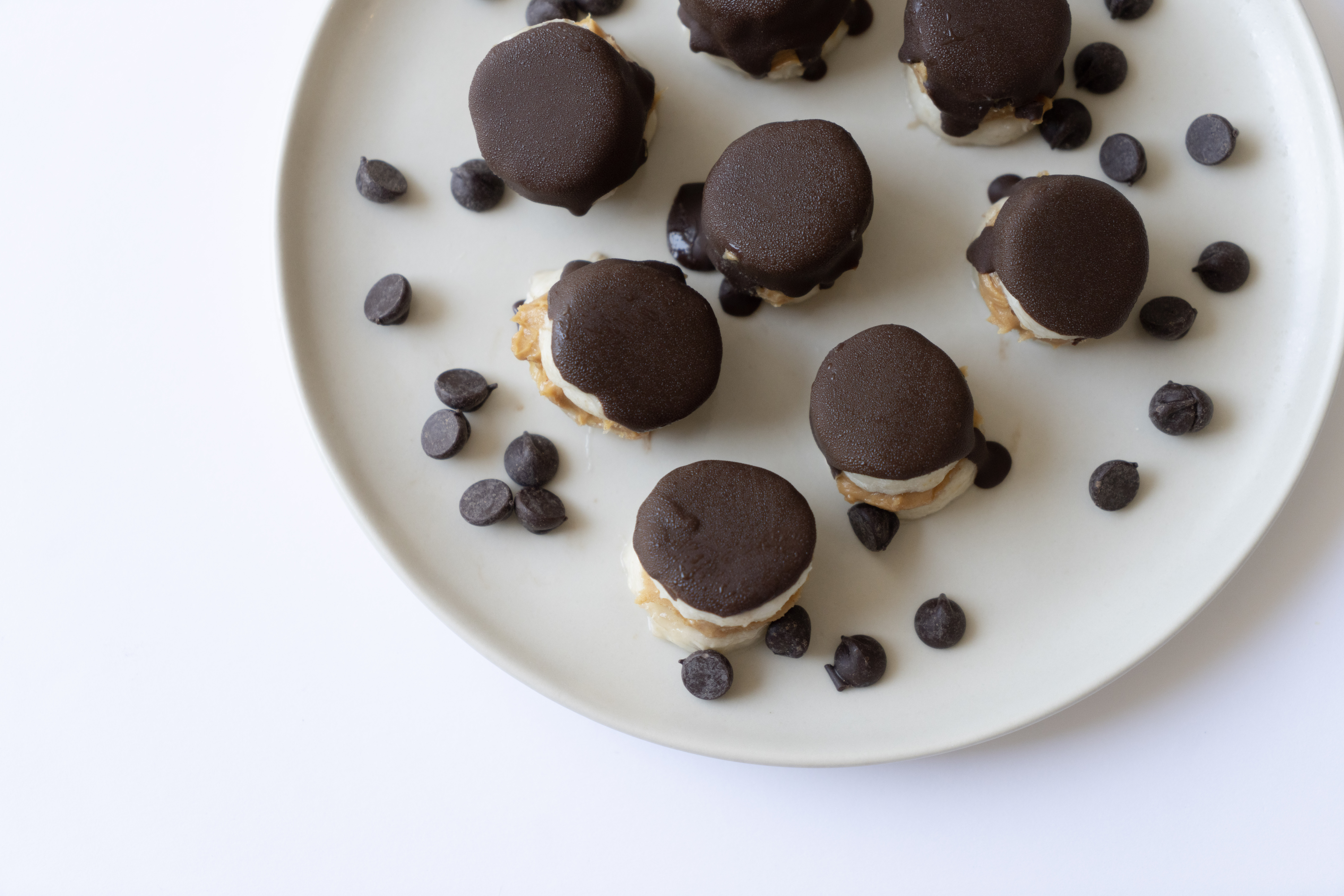peanut butter banana bites with chocolate on a white plate
