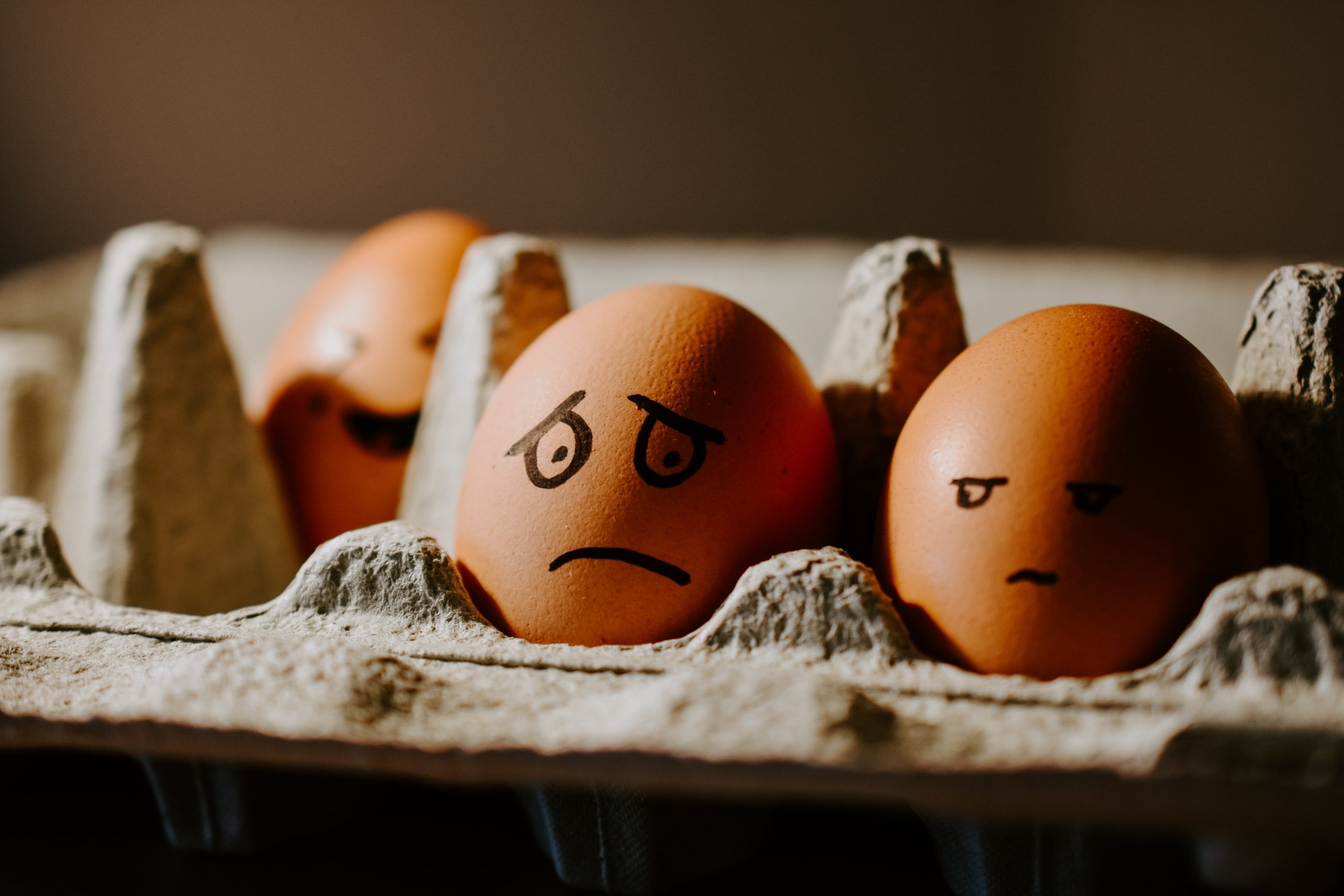 brown eggs in carton with worried faces drawn on with black marker stop worrying