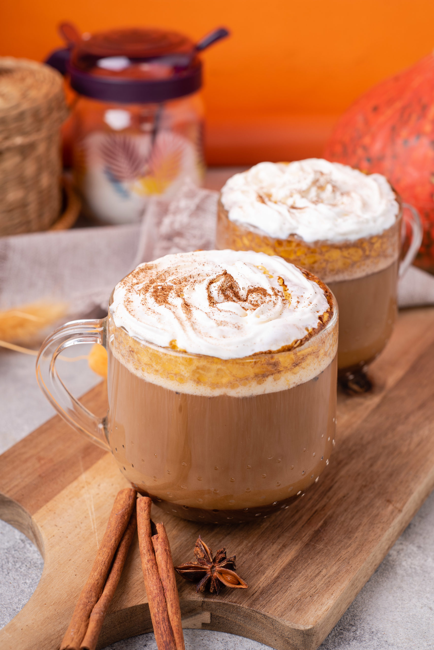 blogilates healthy pumpkin spice latte in clear mugs topped with coconut whipped cream sprinkled with cinnamon