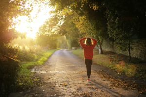 Woman walking through forest or park exercise and mental health