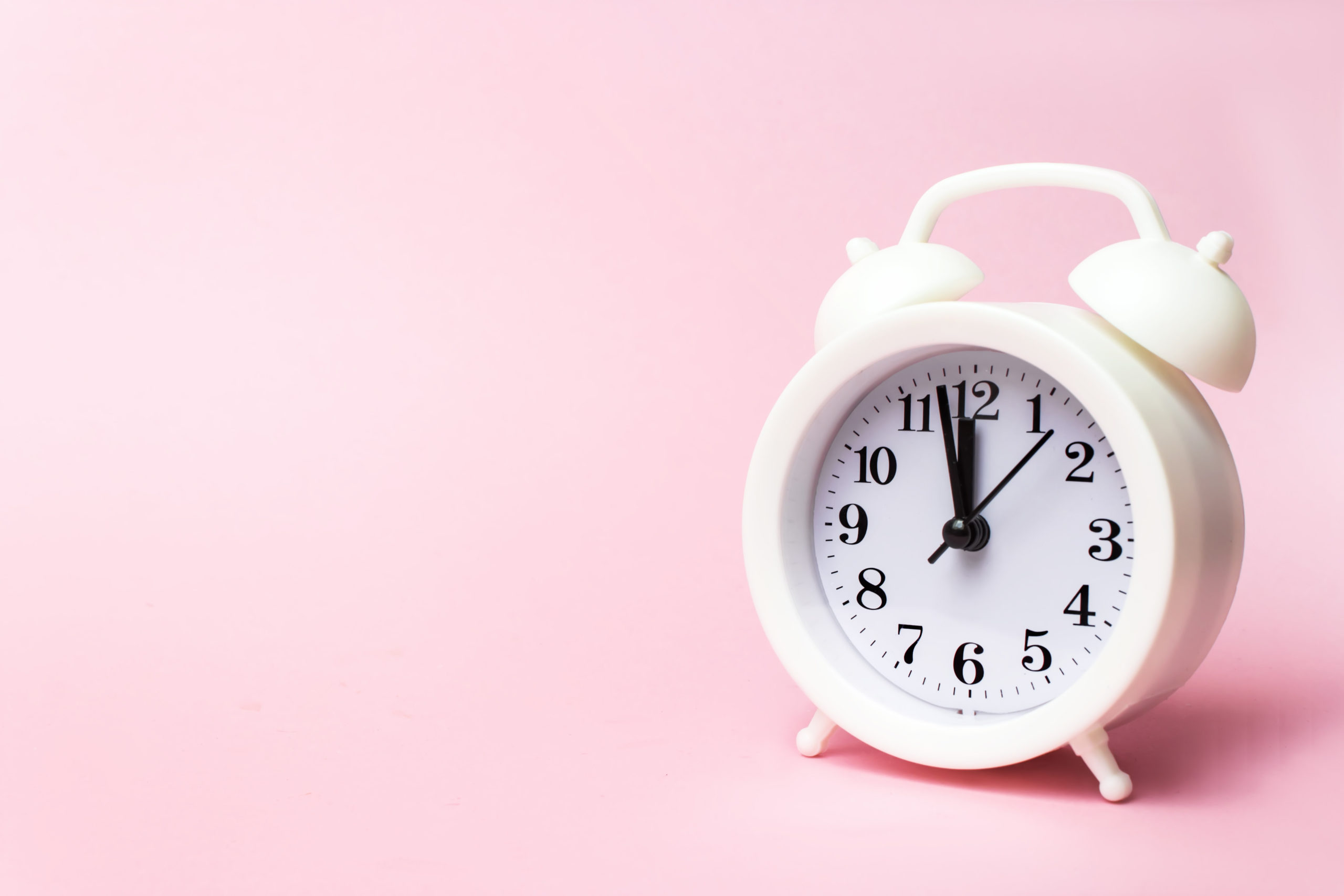 small white clock on pink background intermittent fasting weight loss