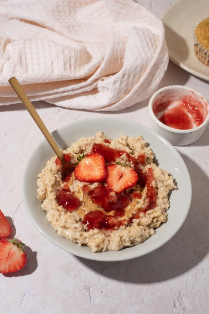 PB&J Protein Oats in a bowl with strawberry jelly swirled on top