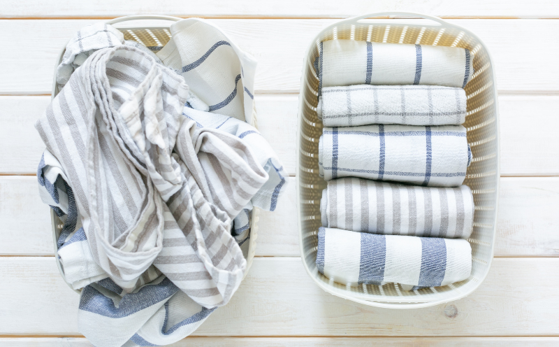 basked of unfolded towels adjacent  to handbasket  of neatly folded towels