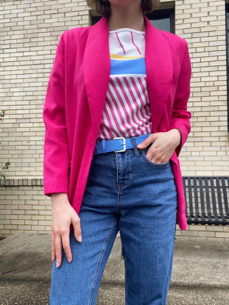 barbiecore outfit inspo pink blazer jeans blue belt colorful top