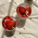 two glasses of non alcoholic strawberry sangria garnished with strawberries