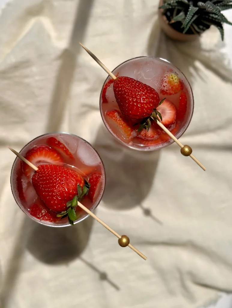 two glasses of non alcoholic strawberry sangria garnished with strawberries