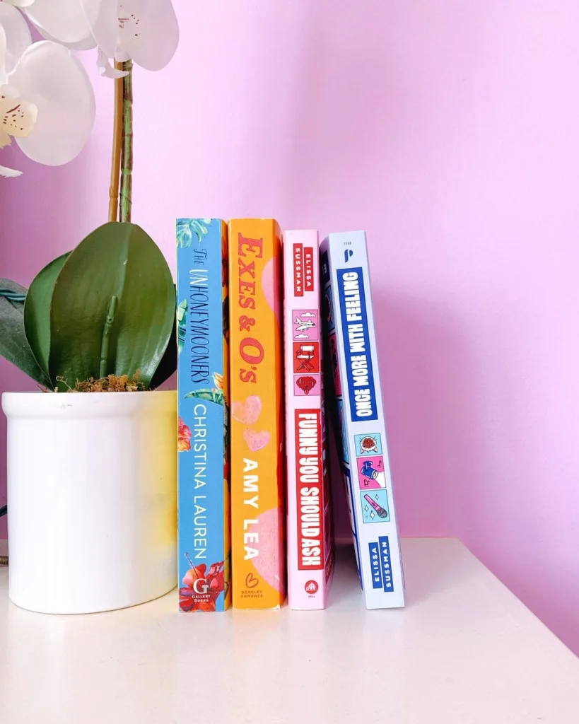 summer beach reads in front of a pink wall and flower