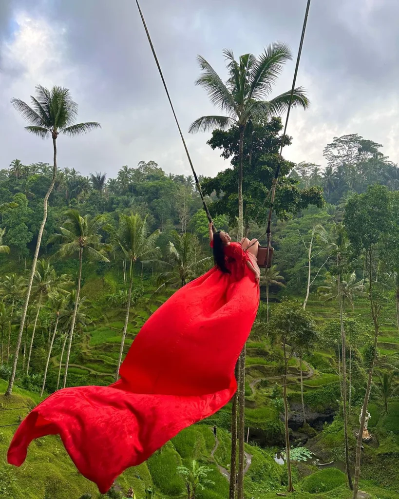 cassey ho in a red flowy dress bali swing